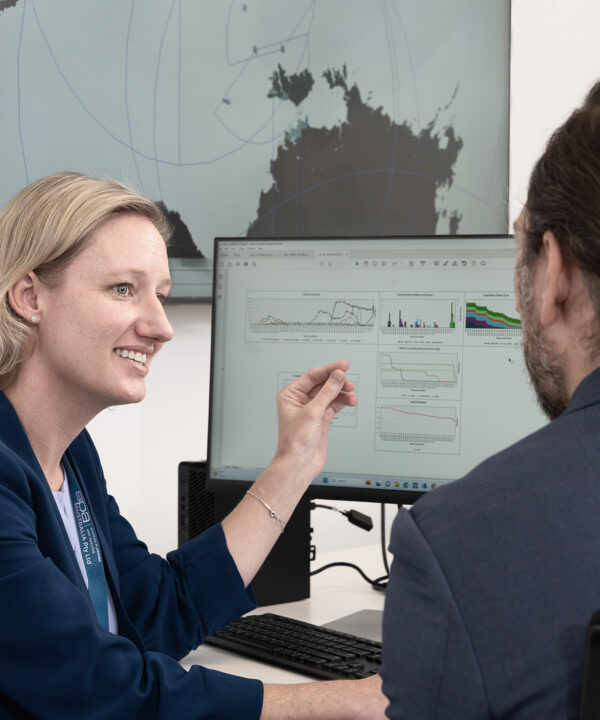 An SPA Australia employee discusses the graphs on her screen with her coworker