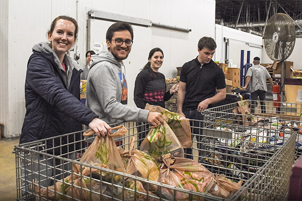 SPA's young professionals pose as they volunteer to work at a local food drive