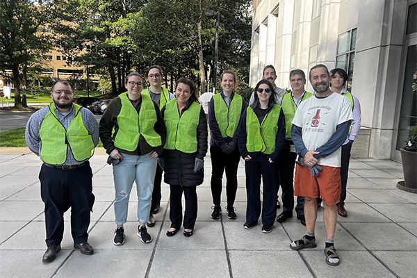 A group of Systems Planning & Analysis employees pose after cleaning up together in the community