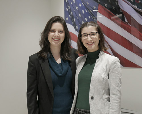 SPA employees pose together in the office with an American flag in the background