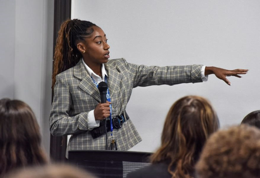 A Systems Planning & Analysis intern points to the board during her presentation and final project