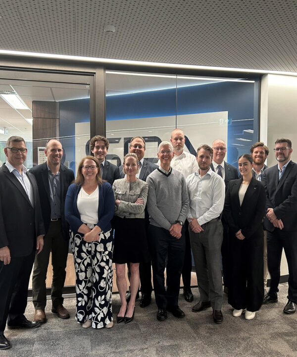 SPA Australia employees pose together in front of office entrance