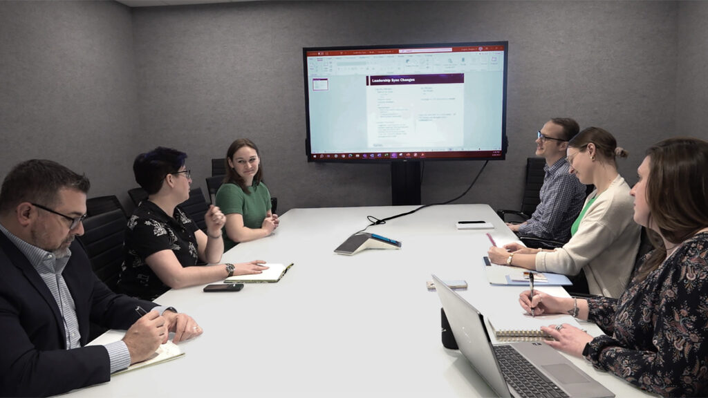 SPA employees meet around a conference table discussing a project they are tasked to complete