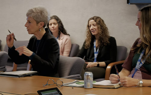 SPA employees discuss a topic during a meeting at HQ