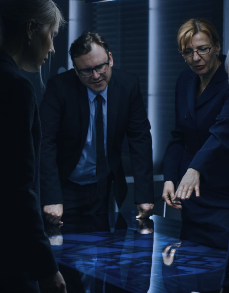 A stock image of employees pointing at a high-tech digital table