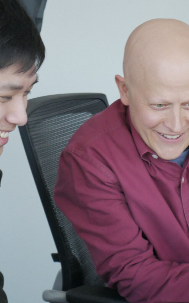 Two SPA employees review a laptop screen together to analyze data