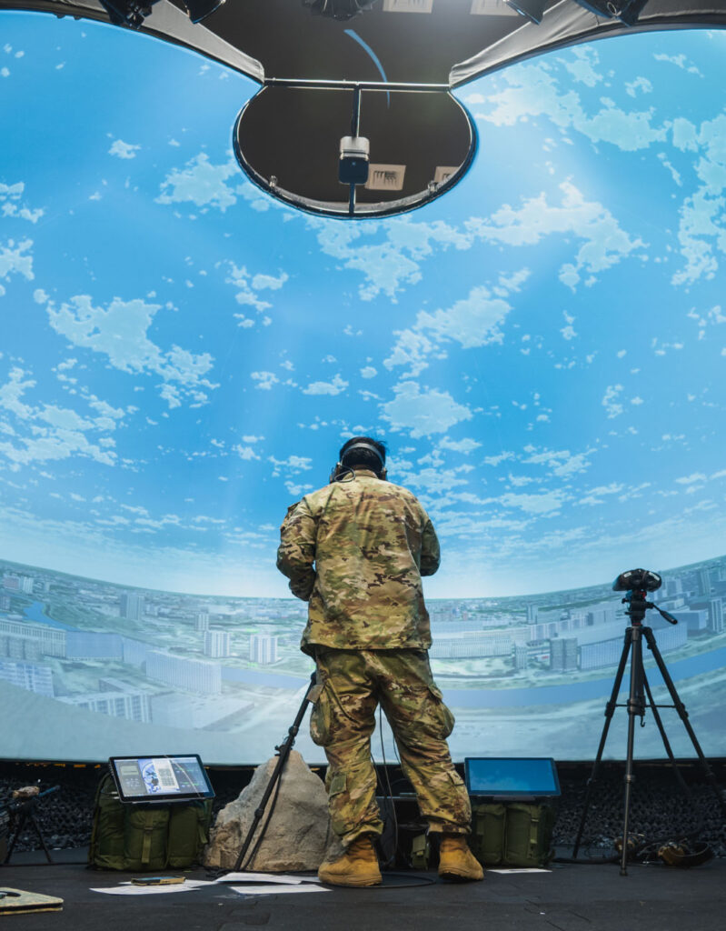 A stock image of a military member standing with VR headset depicting modeling and simulation