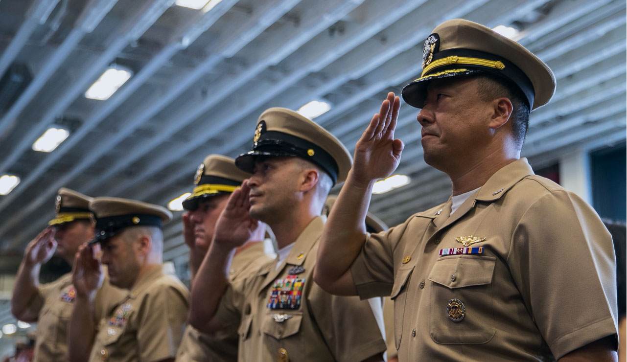 Military members in uniform saluting